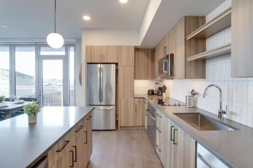 a kitchen with wooden cabinets and a stainless steel refrigerator at Prime Metro Proximity - Condo at Clarendon in Arlington