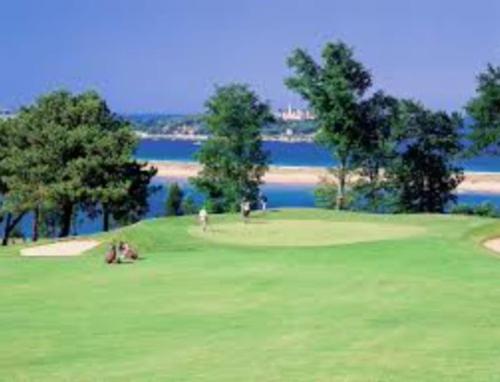 a golf course with a view of the water at Apto Pedreña Golf y Surf in Pedreña