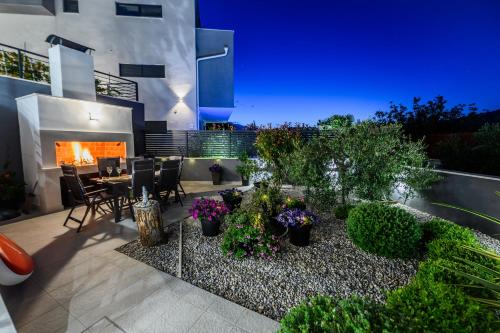 a patio with a table and chairs and a fireplace at Luxury apartment Barka in Villa with heated pool in Vinišće