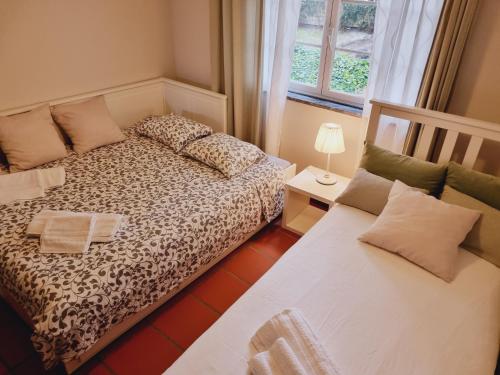 a bedroom with two beds and a window at Apartamento Moura - Praia D’El Rey Golf, Surf & Beach Resort in Casal da Lagoa Seca