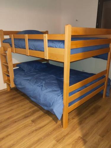 - un lit superposé avec un oreiller bleu sur du parquet dans l'établissement Villa - Saint Bonnet de Mure, à Saint-Bonnet-de-Mure
