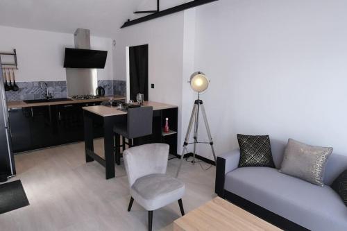 un salon avec un canapé, une table et un bureau dans l'établissement Anubis, à Saint-Hilaire-de-Riez