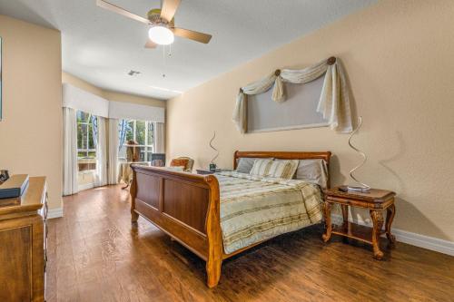 a bedroom with a bed and a ceiling fan at Quiet and Cozy 3 beds 3 baths in Spring Hill with heated Pool and Hot Tub in Spring Hill