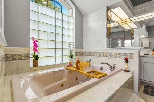 a bathroom with a large tub and a window at Quiet and Cozy 3 beds 3 baths in Spring Hill with heated Pool and Hot Tub in Spring Hill
