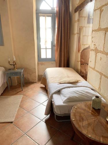 a room with two beds and a table and a window at Chambres d'Hôtes Le Clos des 3 Rois in Thouarcé
