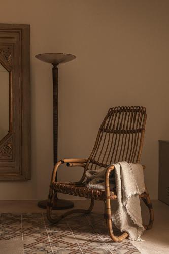a rocking chair and a lamp in a room at Dimora Santagatha in Noto
