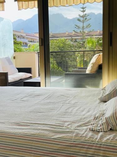 - une chambre avec un lit et un balcon dans l'établissement Beach apartment with tropical garden and mountain view Best location, à Menton