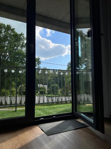 an open glass door with a view of a yard at Apartament Jerzyn in Jerzyn