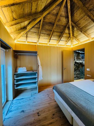 a bedroom with a bed and a wooden ceiling at Villas Calhau da Lapa 10 in Campanário