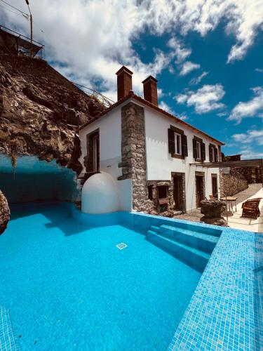 a villa with a swimming pool in front of a house at Villas Calhau da Lapa 10 in Campanário