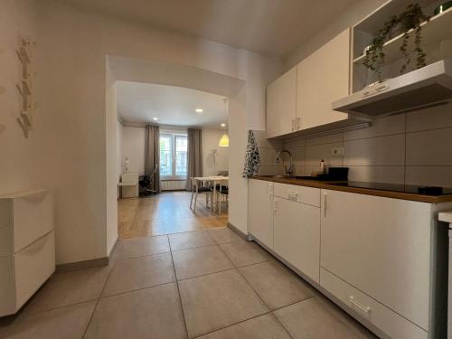 a large kitchen with white cabinets and a table at GARDEN Apartments in Zagreb