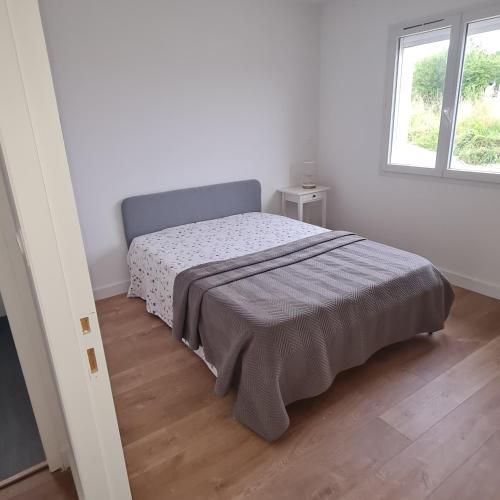 a bedroom with a bed in a white room at maison artigues près bordeaux in Artigues-près-Bordeaux