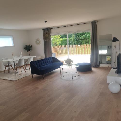 un salon avec un canapé bleu et une table dans l'établissement maison artigues près bordeaux, à Artigues-près-Bordeaux