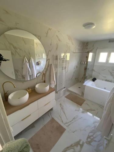 une salle de bain avec deux lavabos et un grand miroir dans l'établissement Luxury &spa, à Garnay