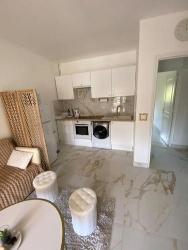 une chambre blanche avec un canapé et une cuisine dans l'établissement Luxury &spa, à Garnay