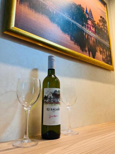 a bottle of wine sitting next to two wine glasses at Diamond in Palić