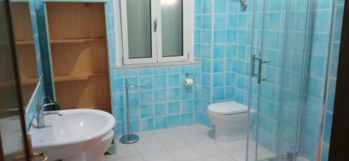 een blauw betegelde badkamer met een toilet en een wastafel bij Ca' da Mariolina in Carloforte