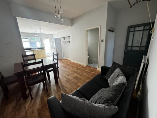 a living room with a couch and a dining room at Double-Bedroom C1 Manchester Close To Bolton Centre in Little Hulton