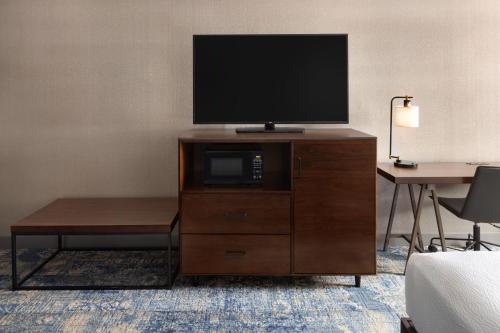 a television on a dresser in a hotel room at Four Points by Sheraton Edmonton South in Edmonton