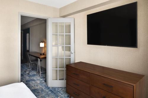 a bedroom with a dresser and a flat screen tv at Four Points by Sheraton Edmonton South in Edmonton