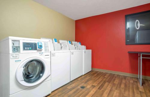 a laundry room with white washers and a red wall at Extended Stay America Suites - Mobile - Spring Hill in Mobile