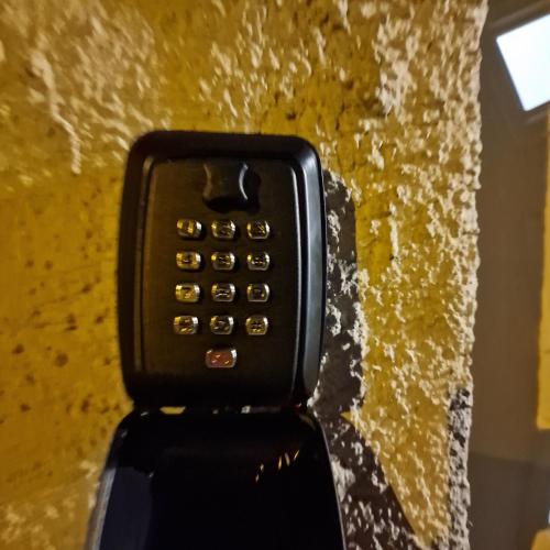 a close up of a cell phone against a yellow wall at les chambres de Sandra in Volognat
