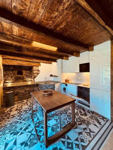 a kitchen with a table on a blue and white floor at Villas Calhau da Lapa 10 in Campanário