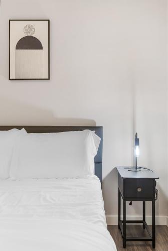 a bedroom with a bed and a side table with a lamp at Dancing Wings Retreat Walker Paradise in Fremont in Seattle