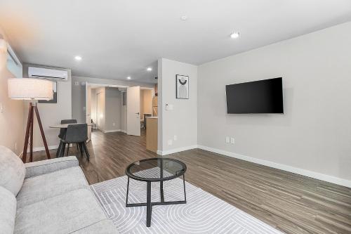 a living room with a couch and a tv on a wall at Dancing Wings Retreat Walker Paradise in Fremont in Seattle