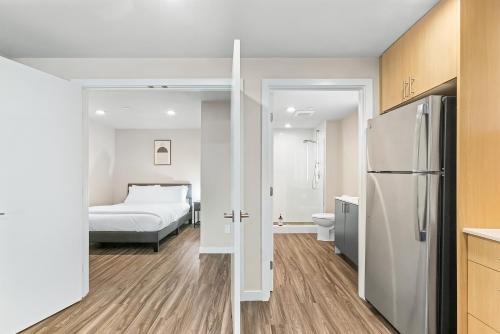 a kitchen with a refrigerator and a bedroom with a bed at Dancing Wings Retreat Walker Paradise in Fremont in Seattle
