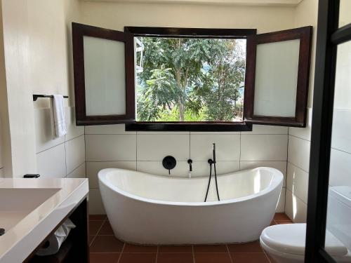 a bath tub in a bathroom with a window at Villa Salento Boutique Apartments & Spa in Salento