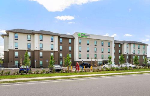 a large building with cars parked in a parking lot at Extended Stay America Premier Suites - Fort Myers - Airport in Fort Myers