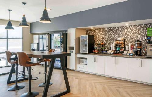 a kitchen with a table and chairs and a counter at Extended Stay America Premier Suites - Fort Myers - Airport in Fort Myers