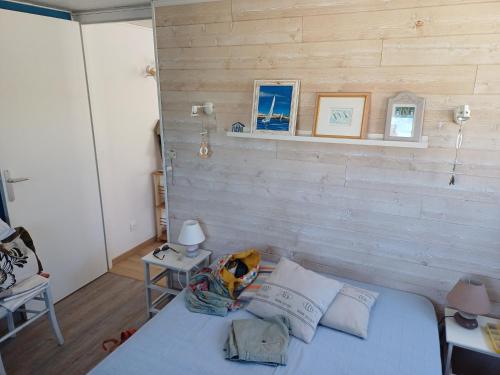 a bedroom with a bed and a wooden wall at Romanjo in Agon Coutainville