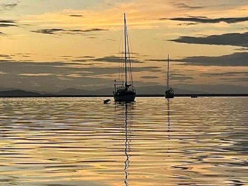two sailboats are sitting in the water at sunset at Villa Bahia Del Sol in Bocas del Toro