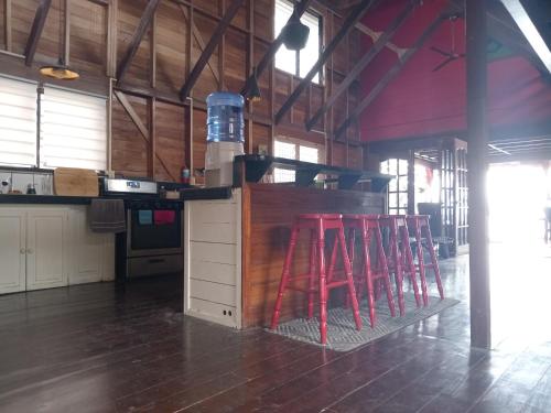 a kitchen with four red stools in a room at Villa Bahia Del Sol in Bocas del Toro