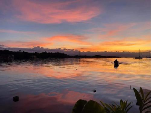 a person in a boat on a lake at sunset at Villa Bahia Del Sol in Bocas del Toro