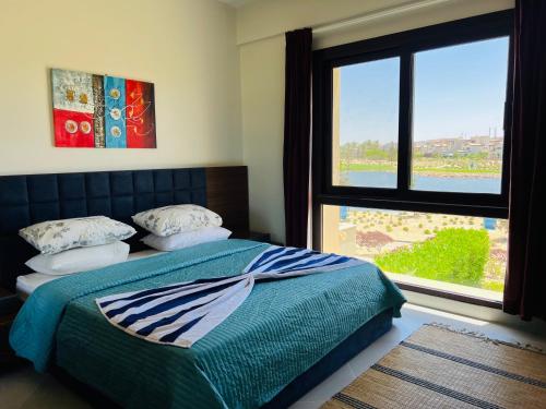 um quarto com uma cama e uma janela grande em شالية في مراسي golf view em El Alamein