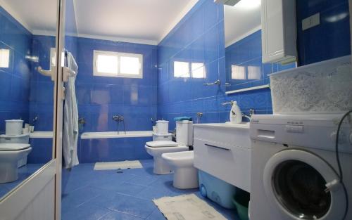培拉特Villa Decolli的蓝色的浴室设有洗衣机。