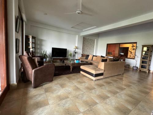 a large living room with couches and a tv at 3-BR Murree Hills Hideaway with Scenic View in Murree
