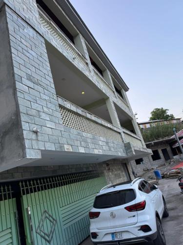 a white car parked in front of a building at 3-BR Murree Hills Hideaway with Scenic View in Murree