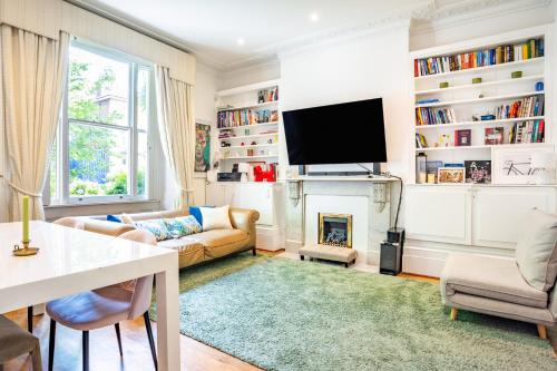 a living room with a fireplace and a tv at Top-quality flat in central London in London