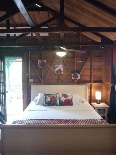 a bedroom with a white bed with wooden walls at Villa Bahia Del Sol in Bocas del Toro