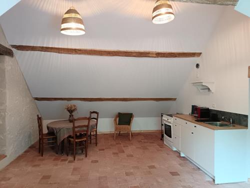 une cuisine avec une table et des chaises dans une pièce dans l'établissement Gîte au milieu des vignes, à Saint-Aignan