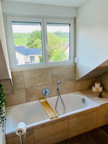 a bath tub in a bathroom with two windows at Design-Apartment II Klimaanlage I Basel 8 km I Boxspring I Nespresso in Weil am Rhein