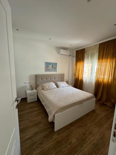 Un dormitorio con una cama y suelo de madera. en Klama Luxury Apartment, en Golem