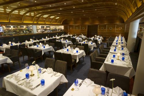 a dining room with white tables and chairs at 4-Sterne Superior Erlebnishotel Bell Rock, Europa-Park Erlebnis-Resort in Rust