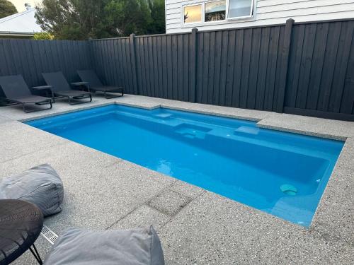a swimming pool in a backyard with a fence at Absolutely Beach in Cowes