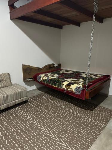 a bedroom with a bed swing and a couch at Recanto do sol in Extrema