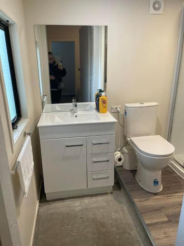 a man taking a picture of a bathroom with a toilet at KK Boarding Holiday house in Hamilton